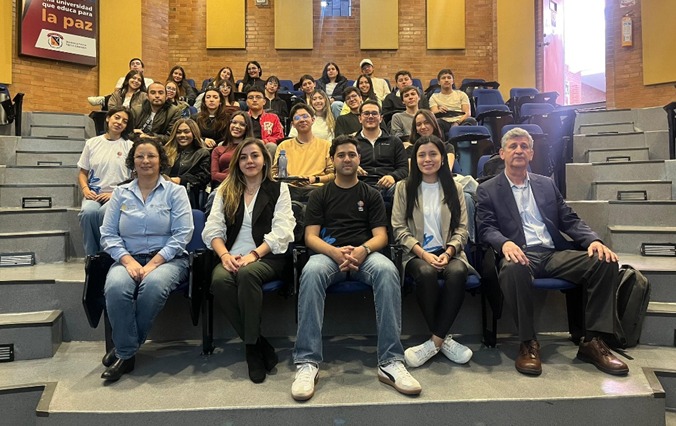 En la imagen se ve al equipo del Observatorio junto a los participantes del Modelo APC Colombia posando para la imagen final del espacio. La foto fue realizada en un salón de la Universidad Militar Nueva Granada