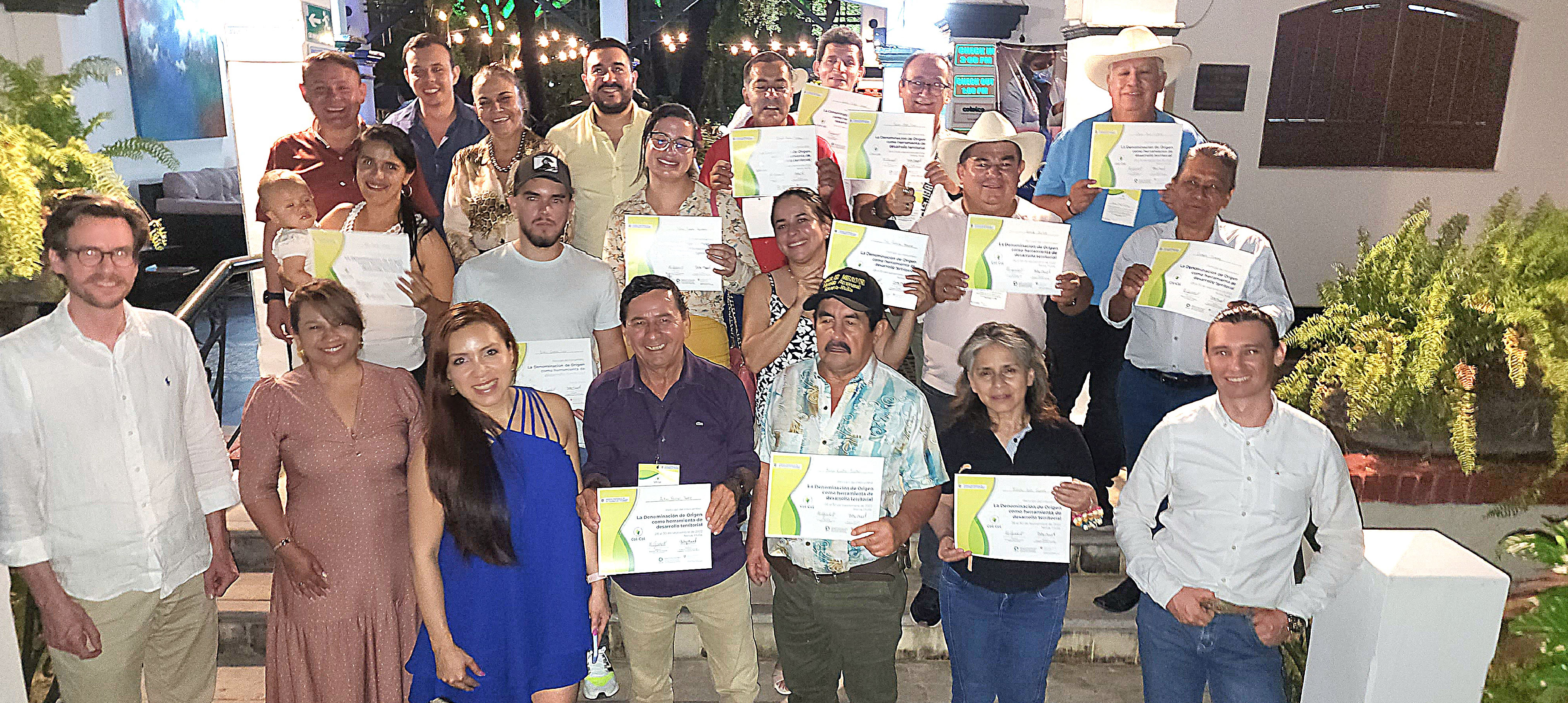 Asistentes al evento Col-Col, sonríen y muestran su certificado