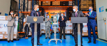 Imagen del Presidente Duque y el embajador de Estados Unidos con sus equipos de trabajo, en la bodega donde estan las cajas con la donación de USAID
