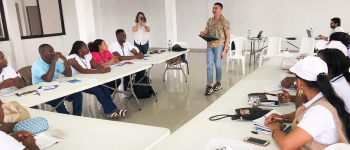 Asistentes a Col-Col, sentados atendiendo las instrucciones de APC-Colombia para el desarrollo de actividades durante el día