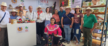 Stand “La Denominación de Origen como herramienta para el desarrollo territorial”. Foto de los asistentes, quienes sonríen a la cámara.