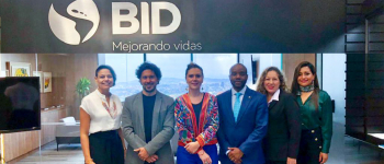 La directora general de APC-Colombia, Eleonora Betancur González con su equipo y el representante del Banco Interamericano de Desarrollo – BID en Colombia, Kelvin Suero con su equipo arriba el logo del BID 