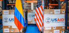 Imagen de las cajas con la donación de USAID acompañadas de las banderas de Colombia y de Estados Unidos