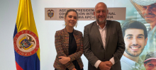 En el medio la directora general de APC-Colombia, Eleonora Betancur González, a la derecha el embajador de Argentina en Colombia, Gustavo Dzuluaga, a la izquierda, la bandera de Colombia