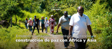 Foto de los participantes del programa de paz "De Colombia al Mundo" caminando en medio de un sendero con varias plantas